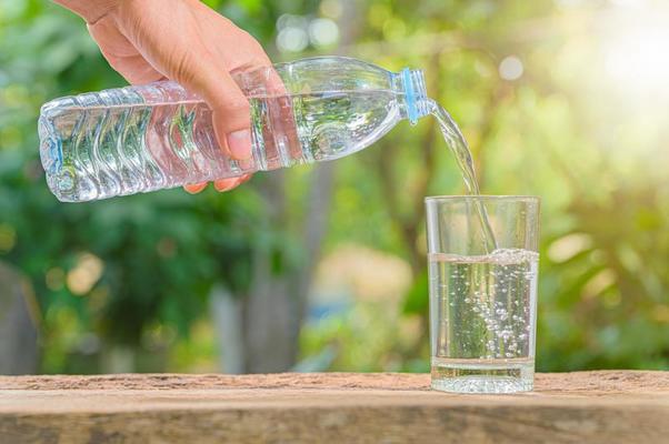 Bottle of drinking water and glass with water